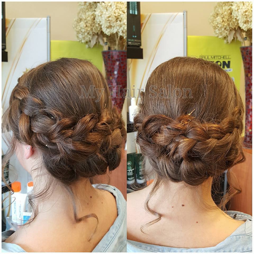 A woman has her hair in a braided bun