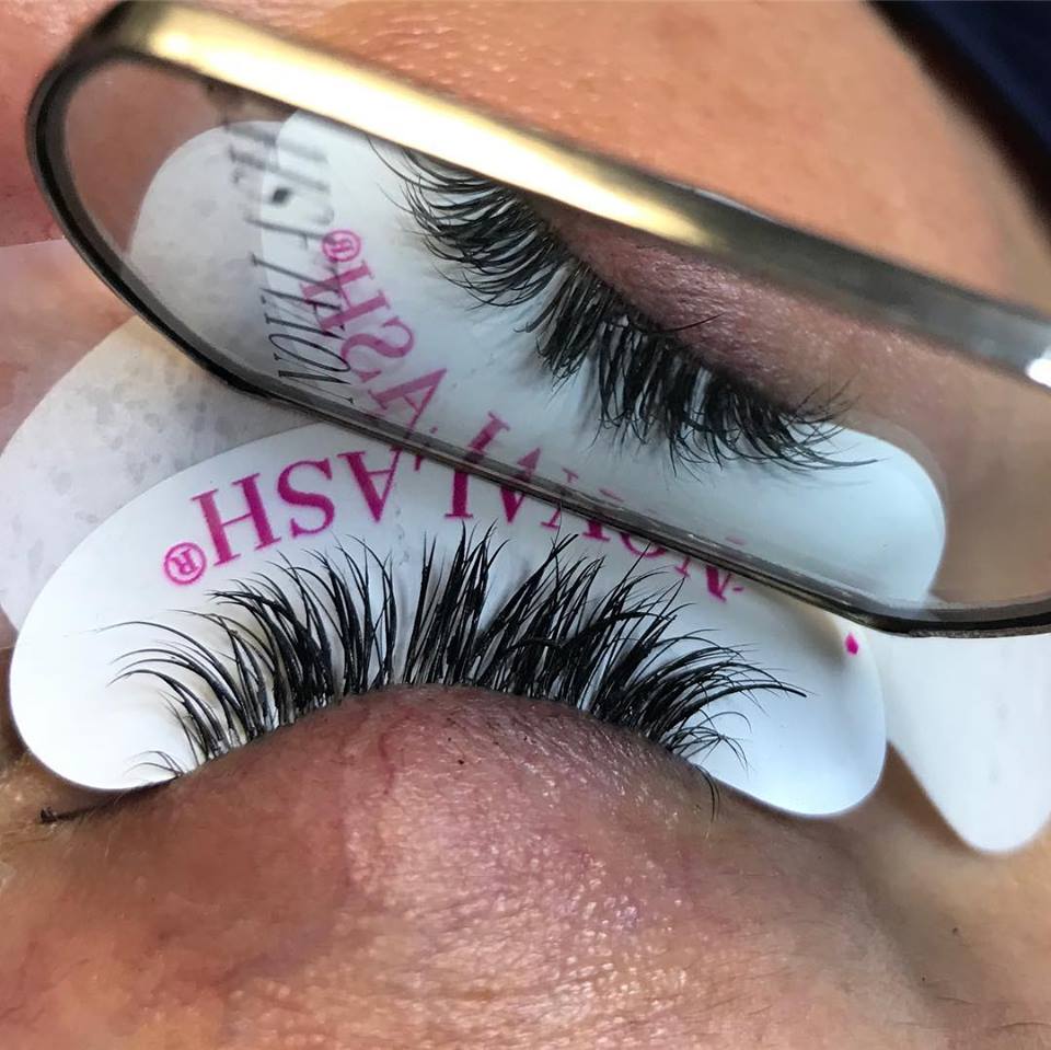 A close up of a woman 's eye with glasses and fake eyelashes.
