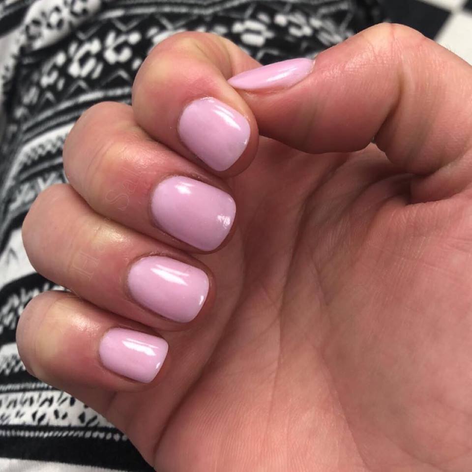 A close up of a person 's hand with pink nails