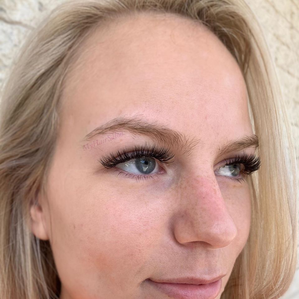 A close up of a woman 's face with long eyelashes.