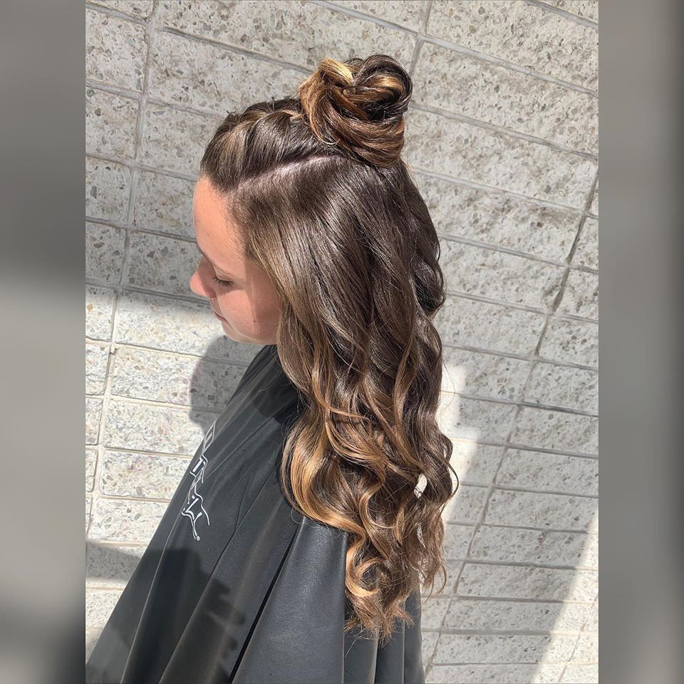 A woman is wearing a black cape and has her hair in a bun.