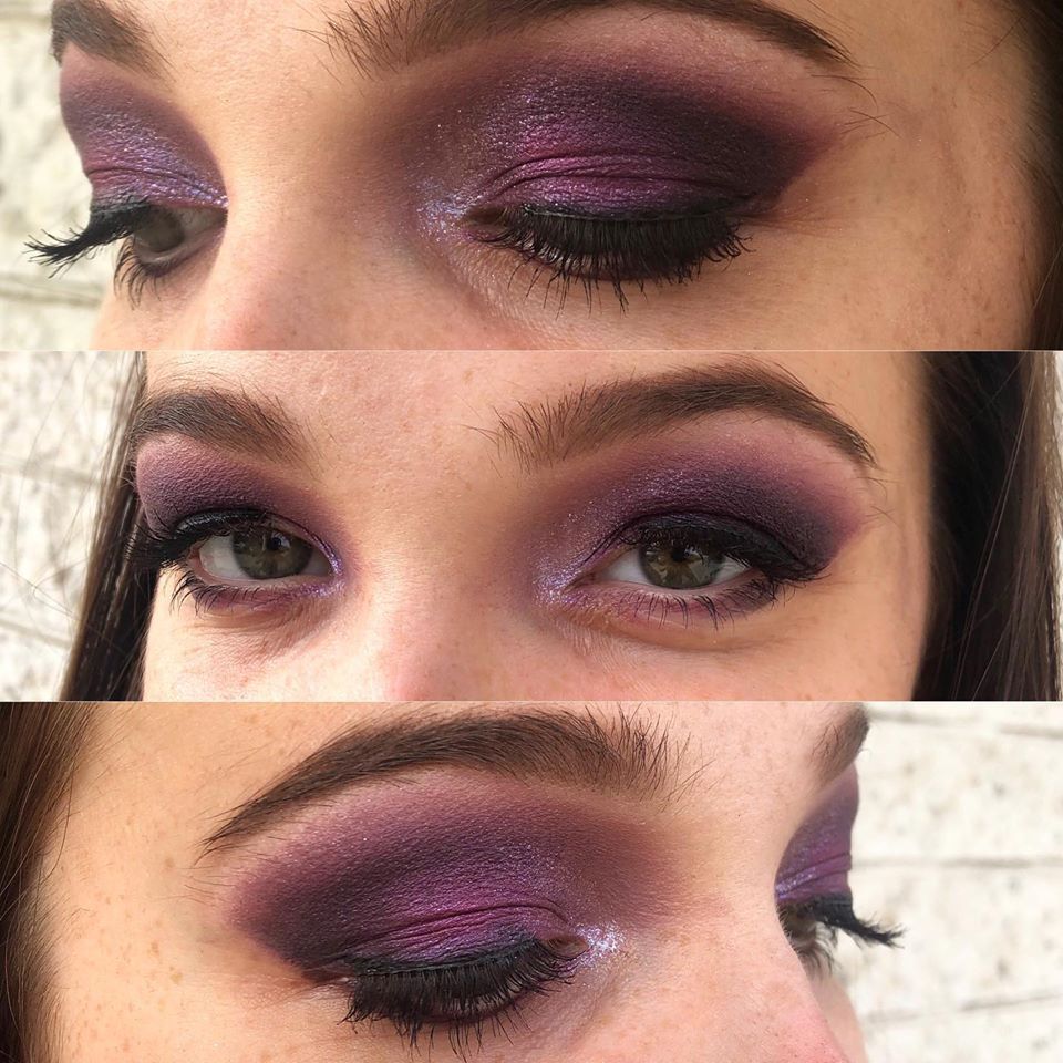 A close up of a woman 's eyes with purple eyeshadow.