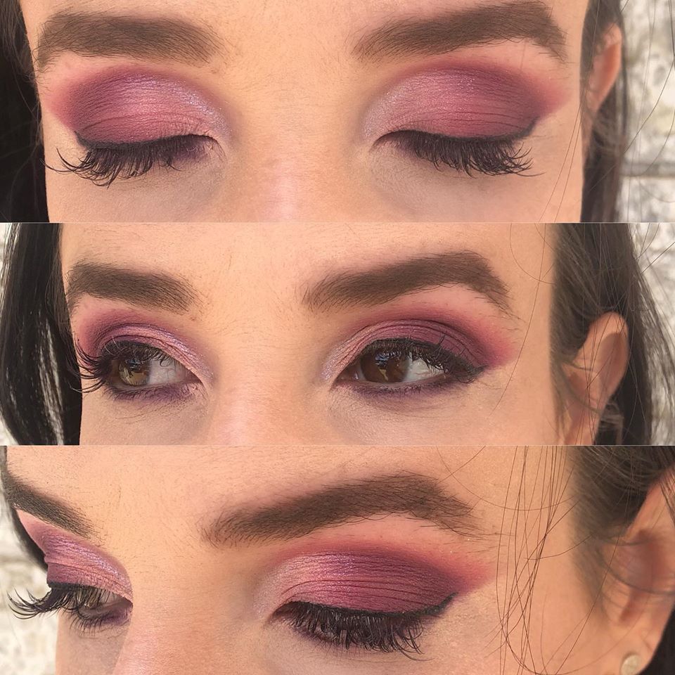 A close up of a woman 's eyes with purple eyeshadow