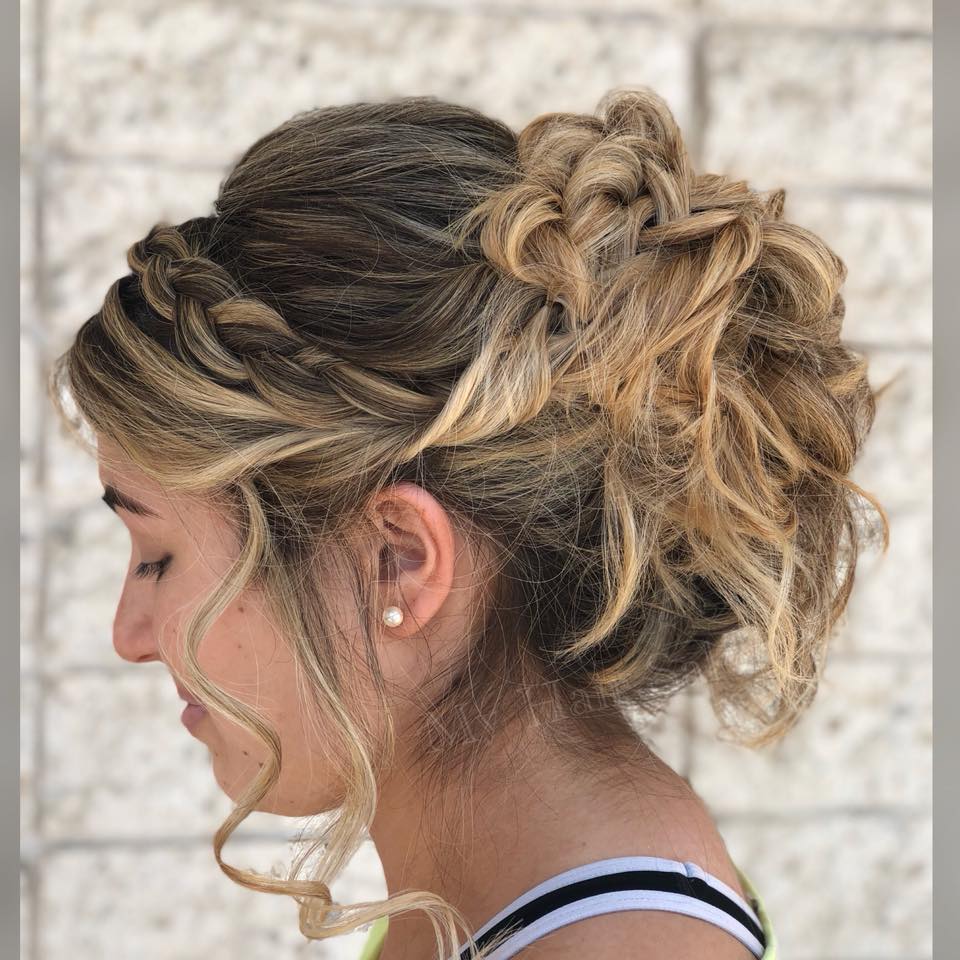 A woman is wearing her hair in a messy bun.