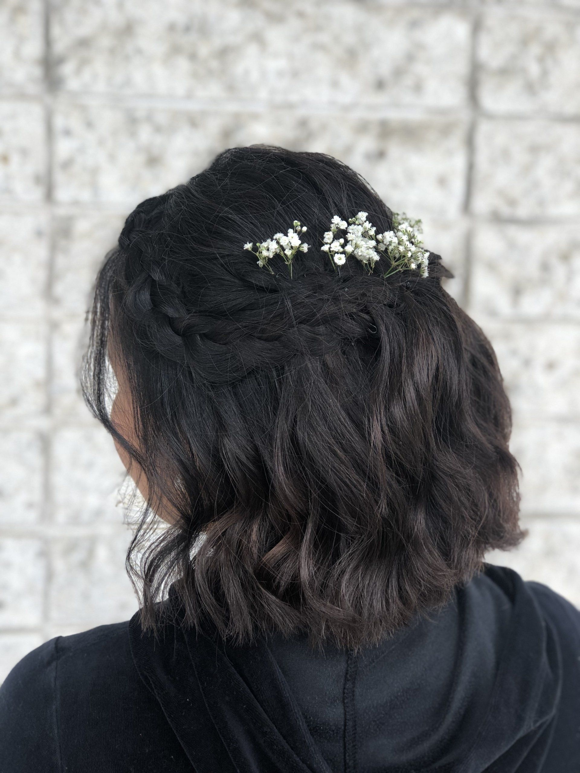 The back of a woman 's head with flowers in her hair.