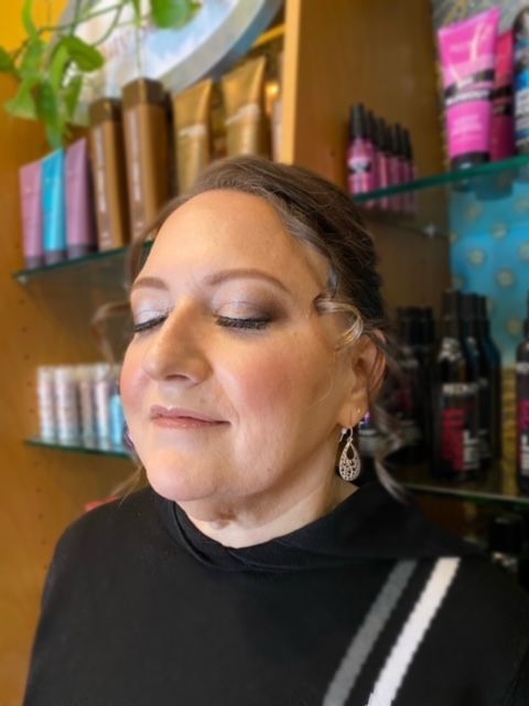 A woman is getting her makeup done in a salon.
