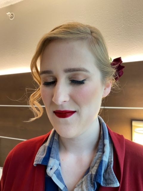 A woman wearing red lipstick and a red jacket
