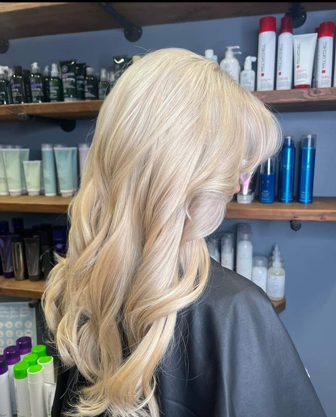 A woman with blonde hair is sitting in a hair salon.
