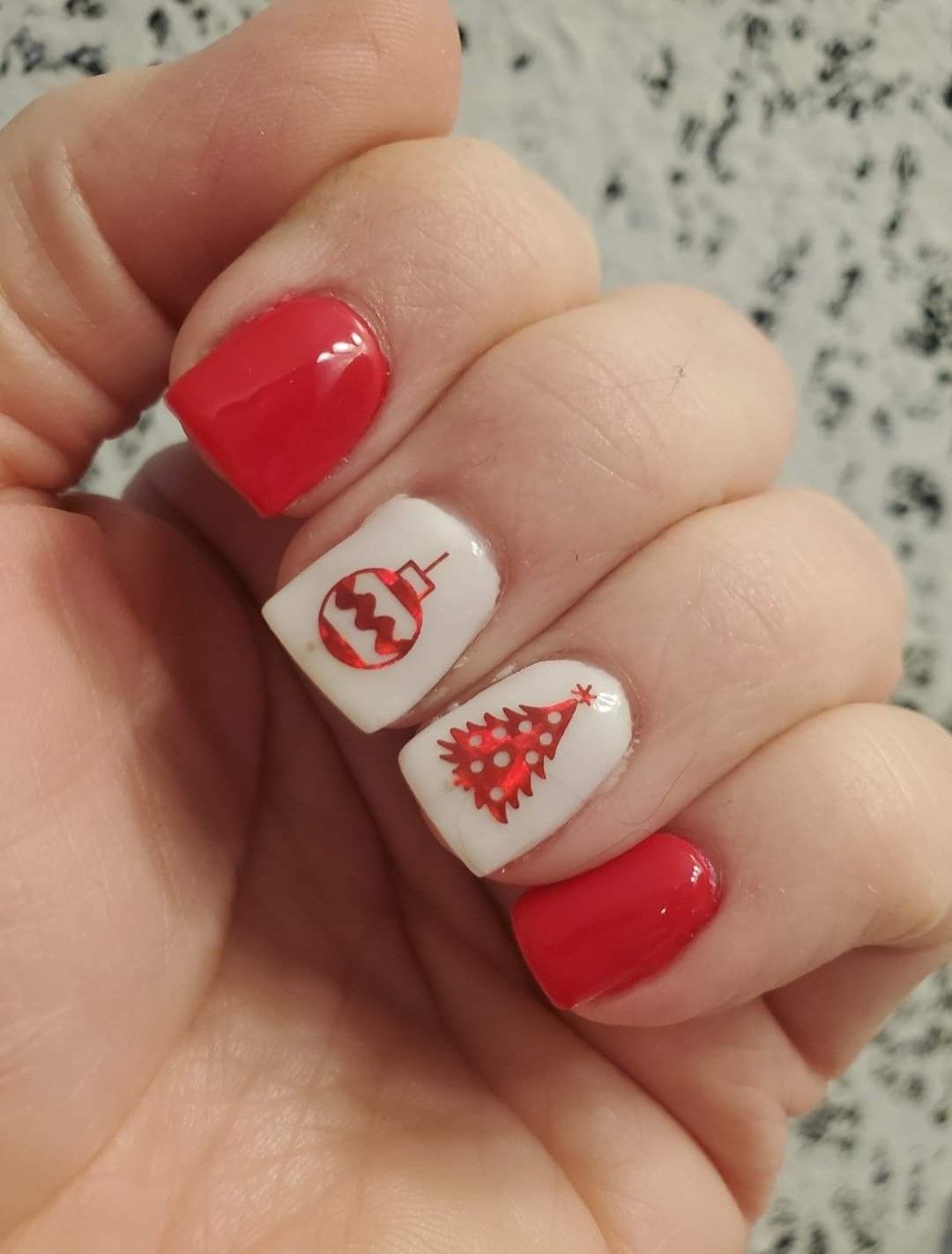 A close up of a person 's nails with a christmas tree design