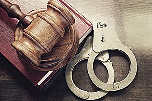 Handcuff, legal book and gavel