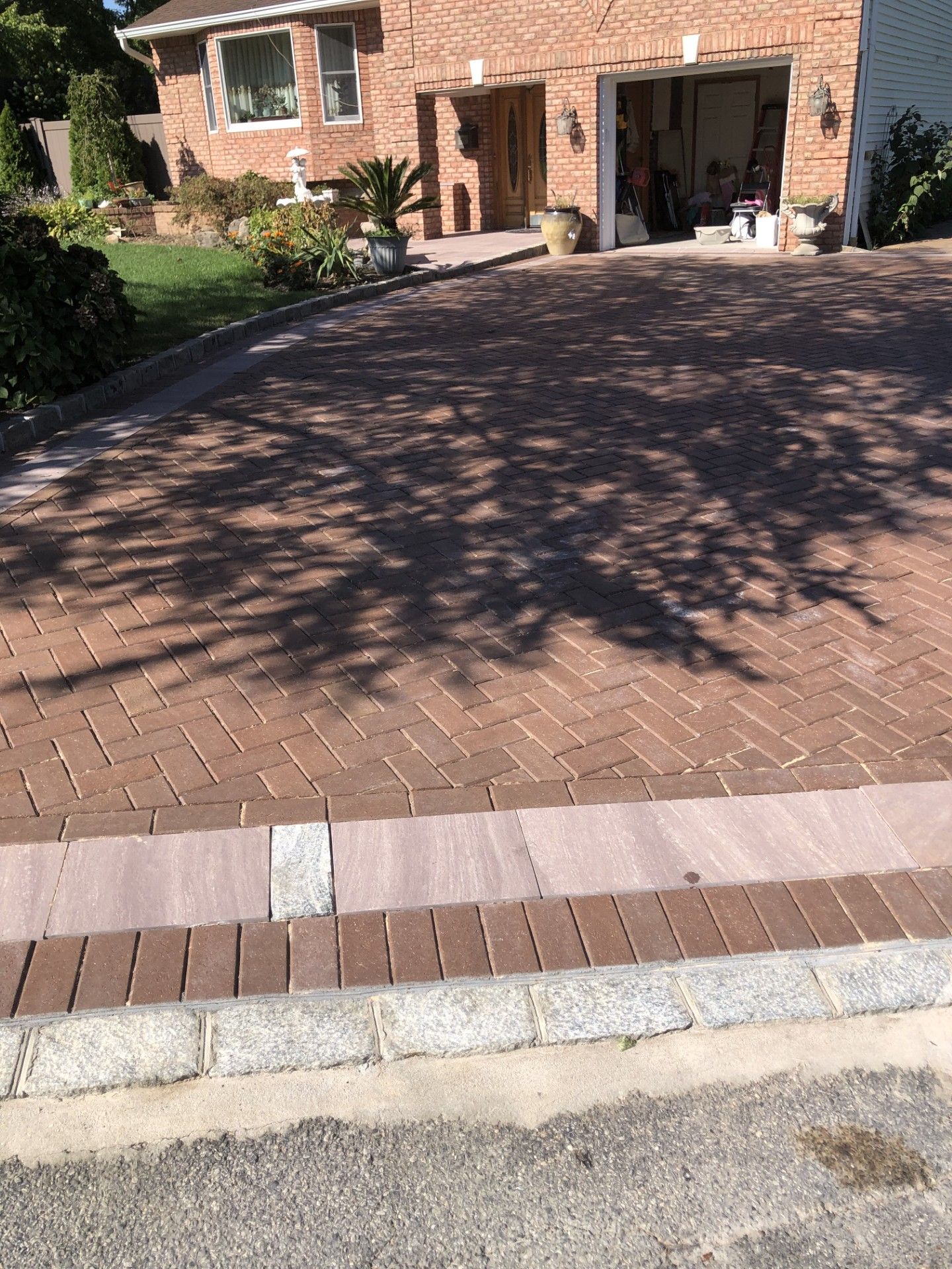 A brick driveway in front of a brick house