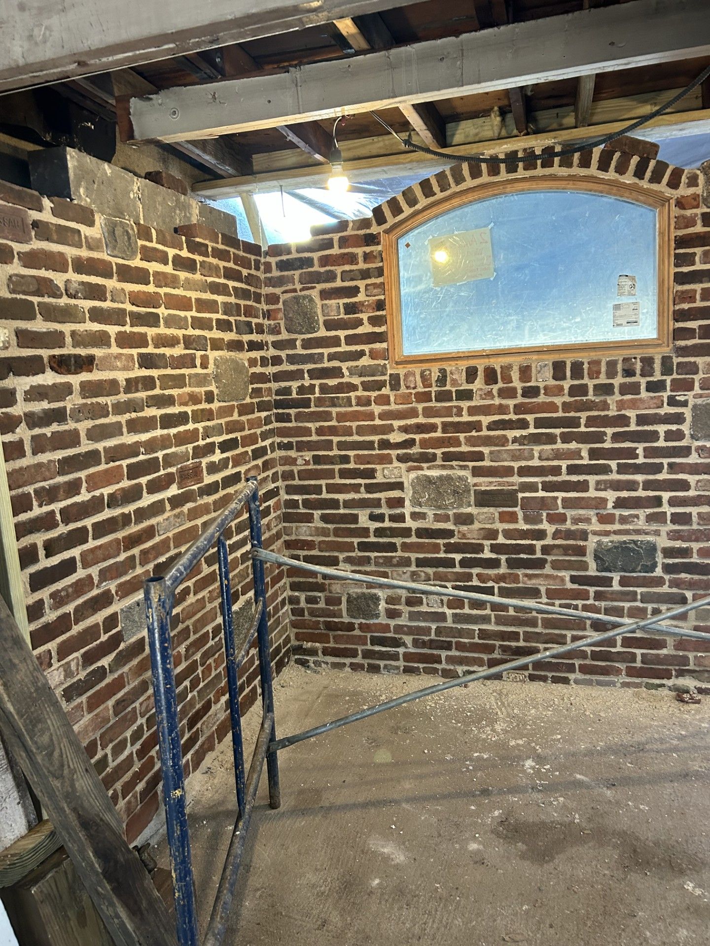 A room with a brick wall and a window.