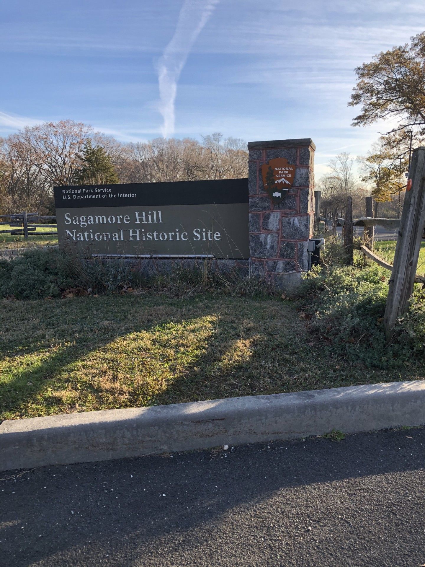 A sign for a national historic site is sitting on the side of the road.