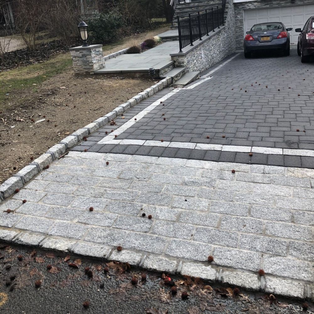 A car is parked in a driveway next to a garage