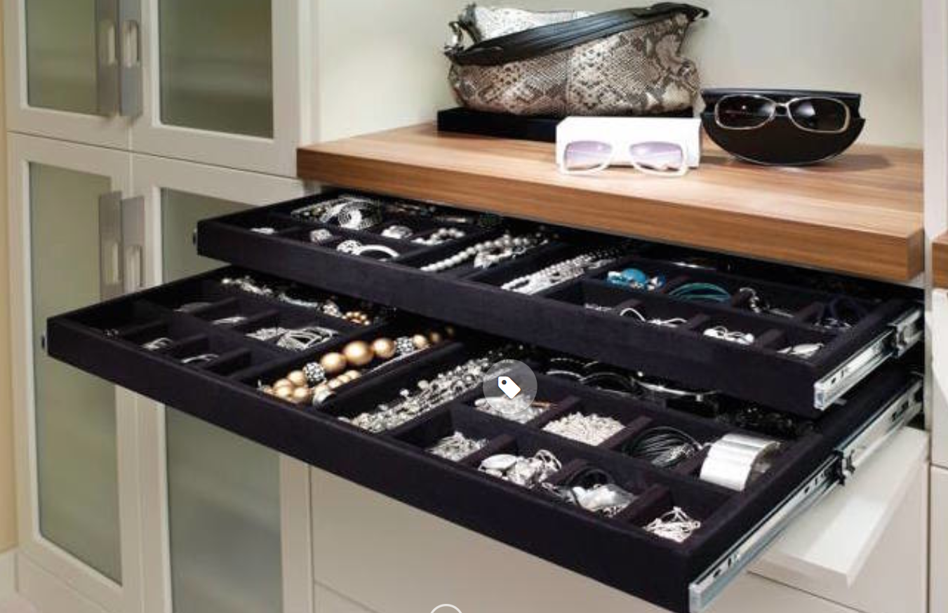Jewelry drawers filled with necklaces, rings, and bracelets. Sunglasses and a handbag sit above.