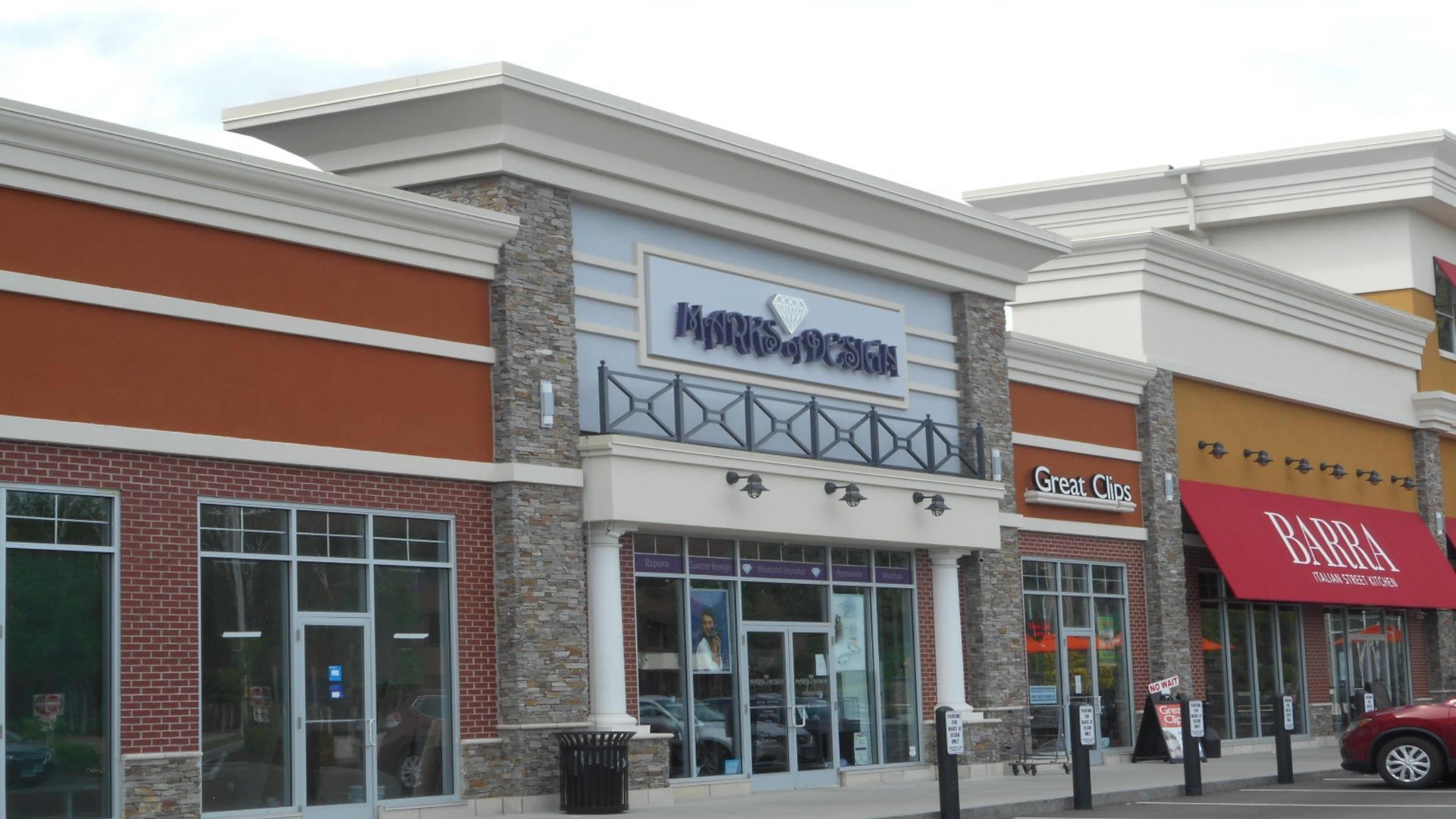 Main entrance of a Marshalls store in a shopping center, with other stores visible; orange, brown, and tan colors.