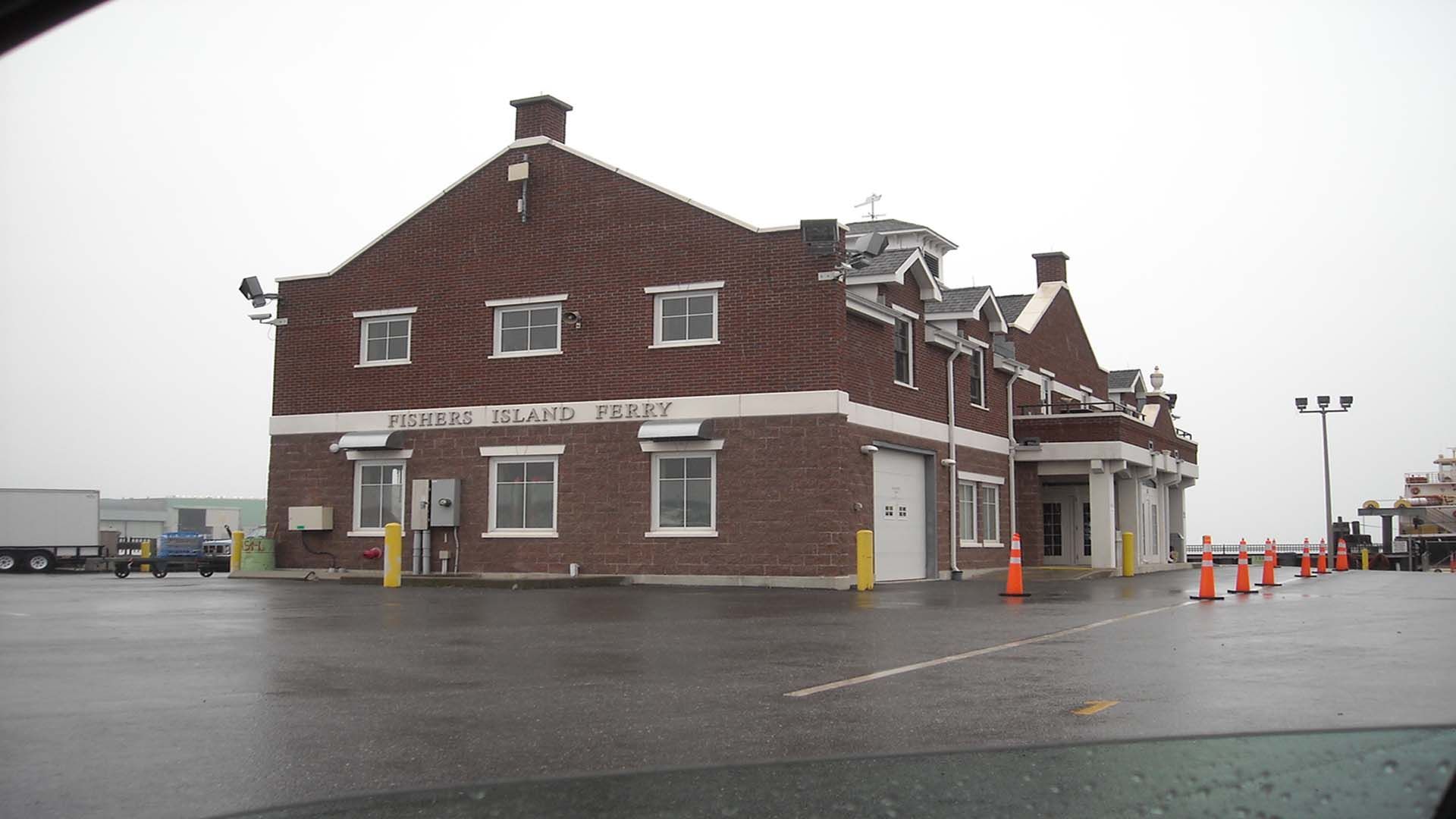 Brick building: New York Seaport Fire Dept. under a cloudy sky with a wet parking lot.