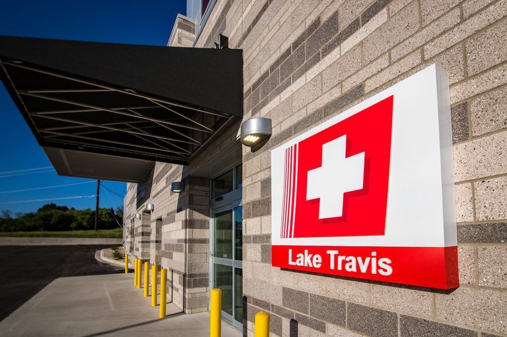 A red and white sign on the side of a building that says Lake Travis