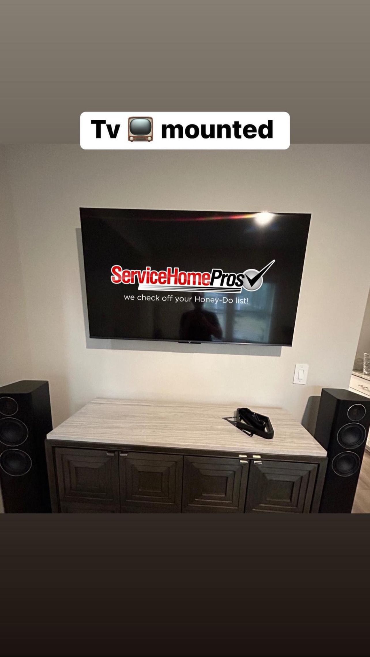 A tv mounted on a wall above a table in a living room.