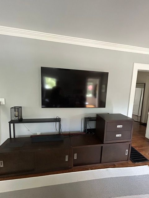 A living room with a flat screen tv mounted on the wall.