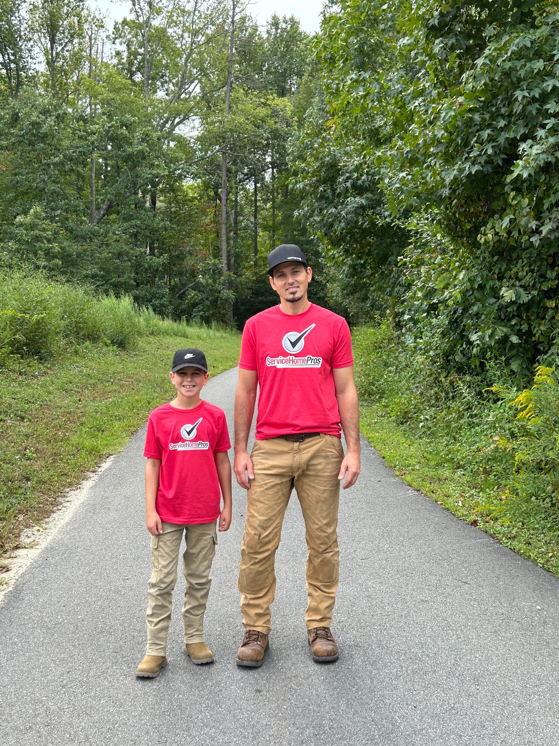 A man and a boy are standing next to each other on a path.