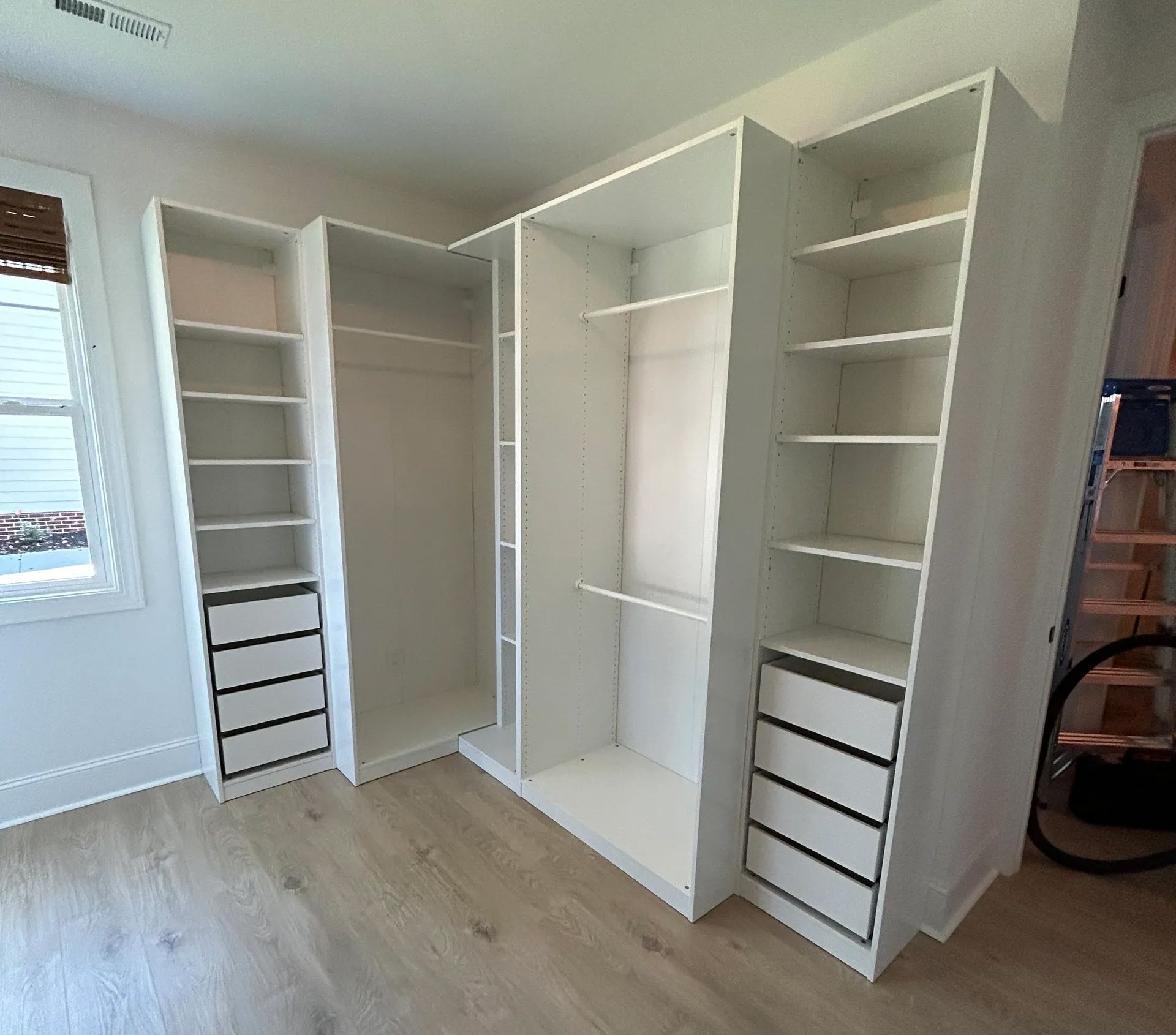 A walk in closet with lots of shelves and drawers in a room.