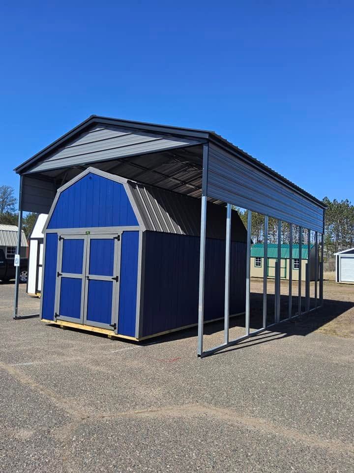 Blue and white outdoor shed with a metal roof on a paved lot under a clear sky