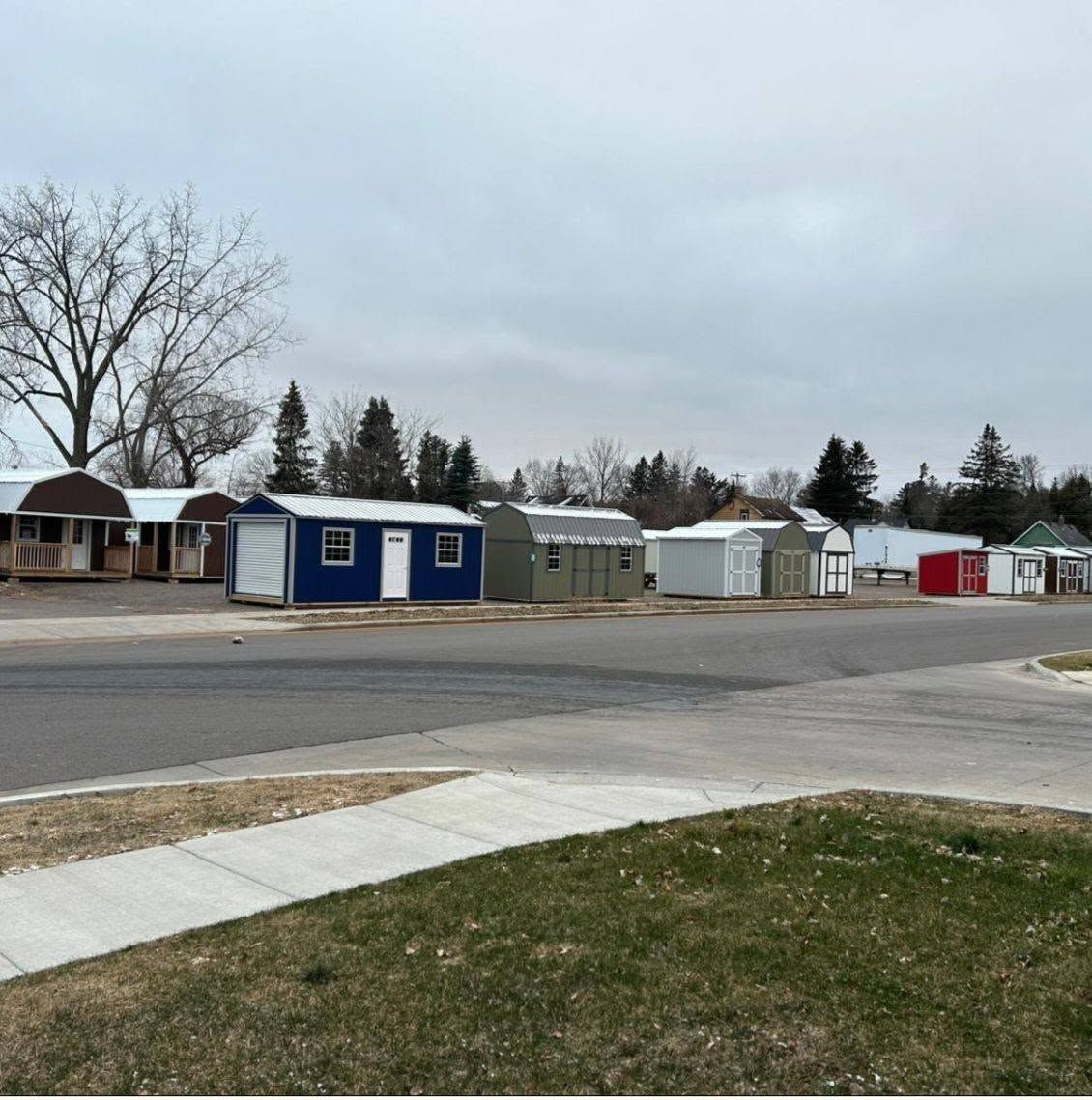 Row of small colorful market sheds along a quiet street under a cloudy sky