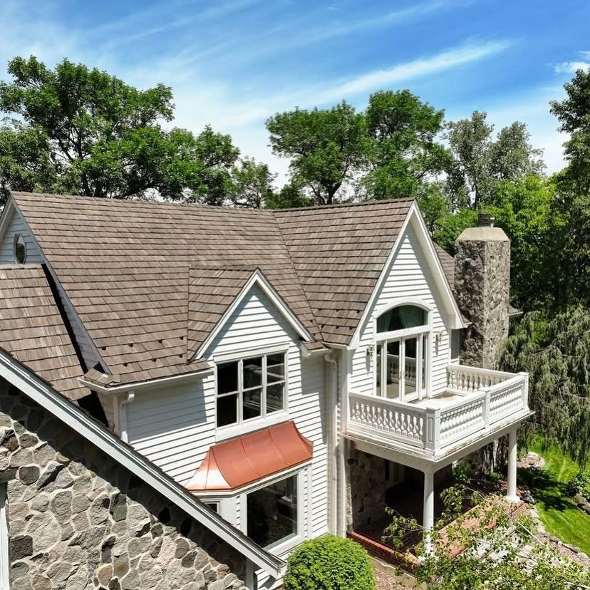 A large white house with a brown roof and a balcony