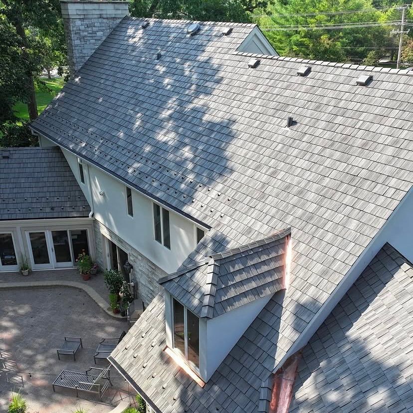 An aerial view of a house with a gray roof