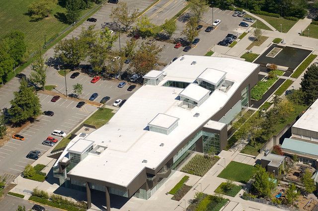 An aerial view of a large building with a white roof