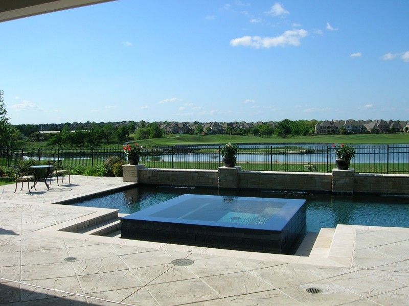 A large swimming pool with a hot tub in the middle