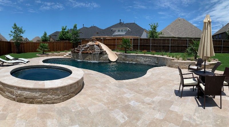 A large swimming pool with a slide and a hot tub