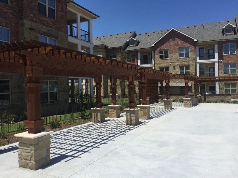A brick building with a pergola in front of it