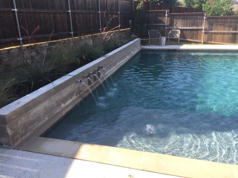 A large swimming pool with a wooden fence in the background