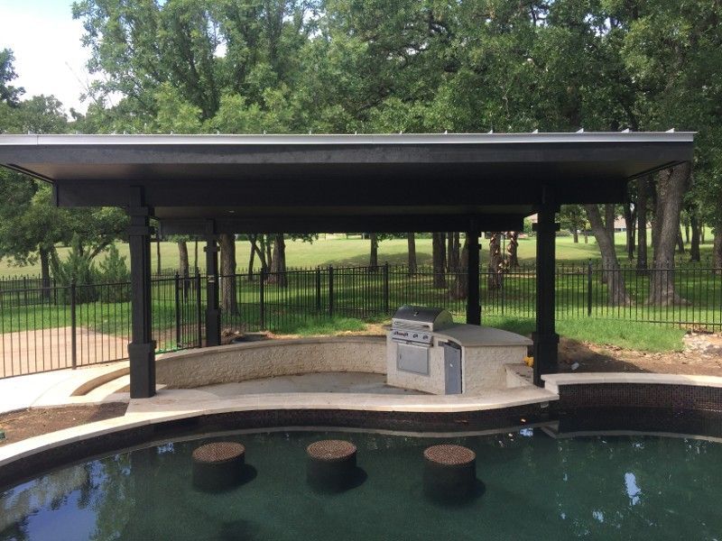 A swimming pool with a grill under a canopy