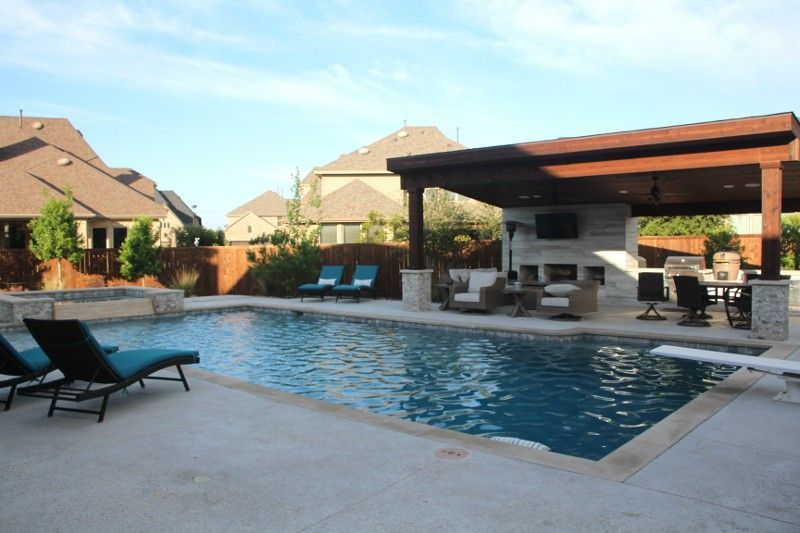 A large swimming pool surrounded by chairs and a covered area