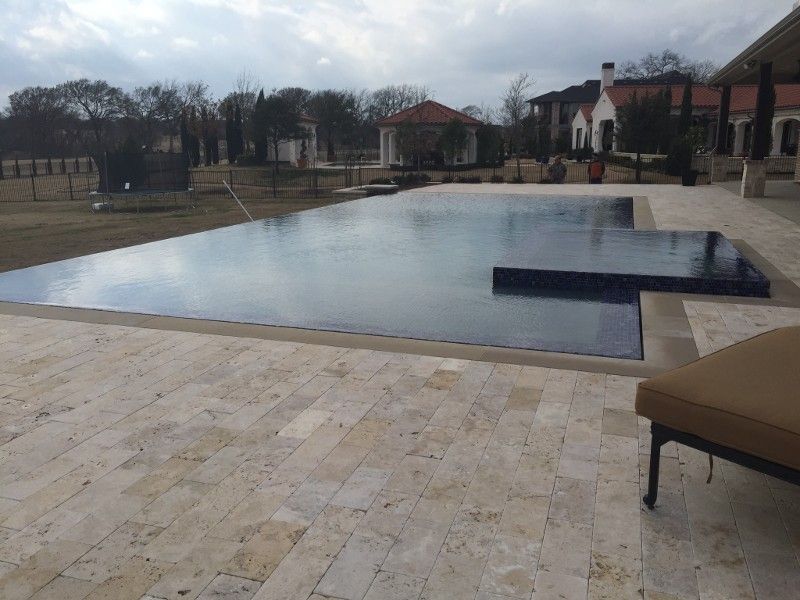 A large swimming pool with a house in the background