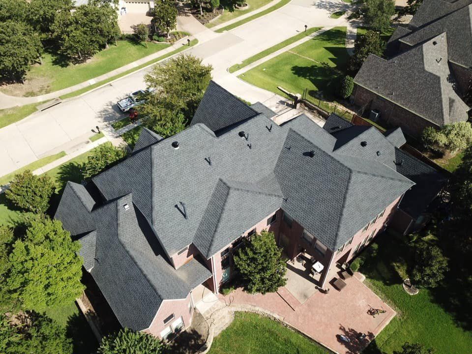 An aerial view of a house with a lot of roofs