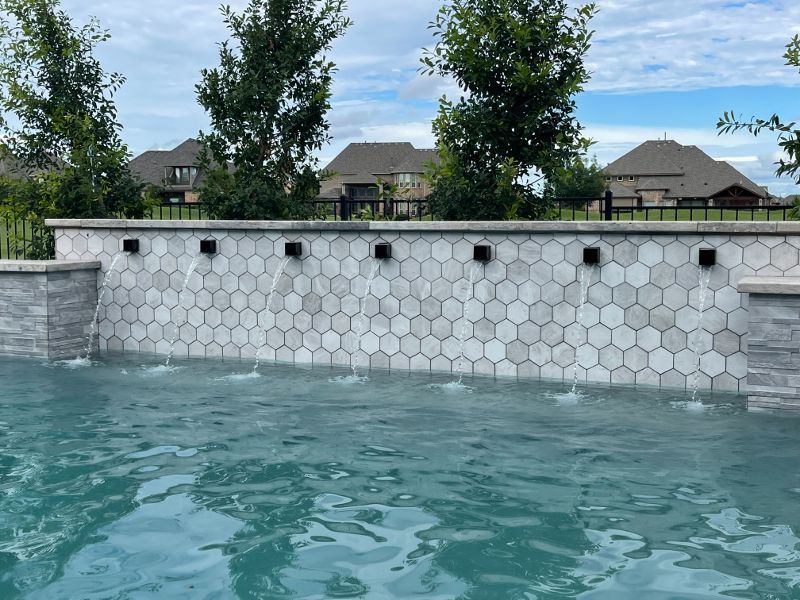 There is a waterfall in the middle of the pool.