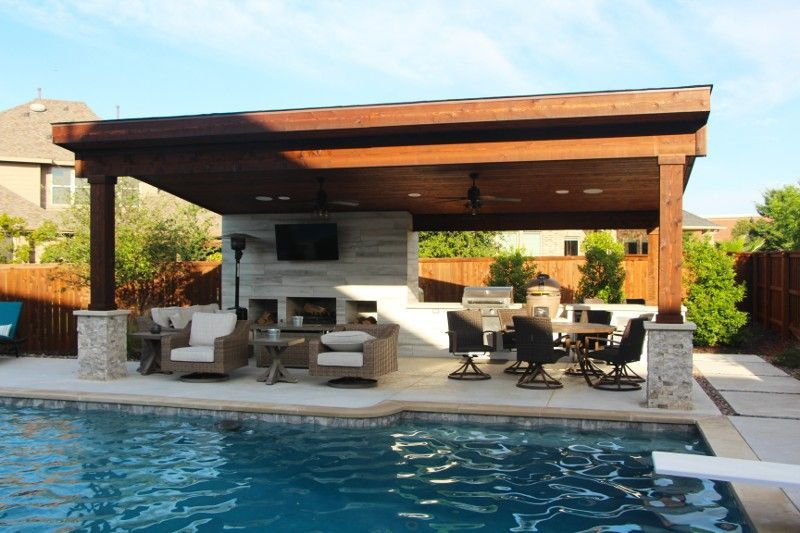 A large swimming pool with a wooden pavilion over it