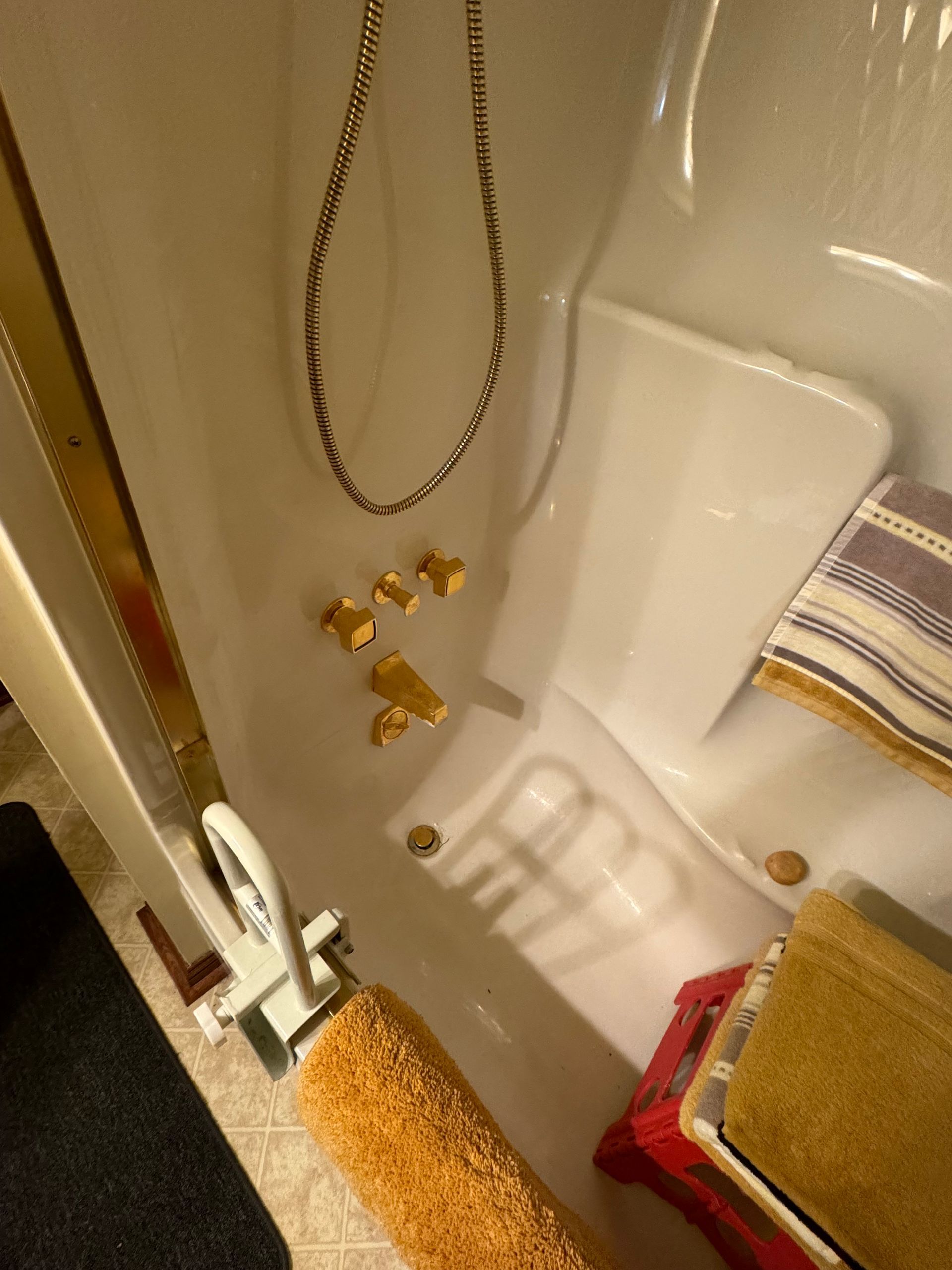 A bathroom with a shower and towels on the floor