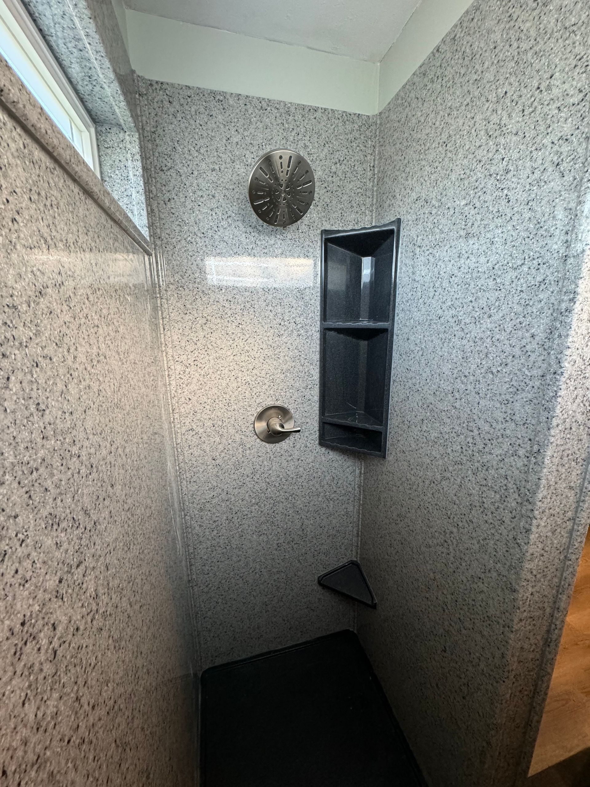 A bathroom with a walk-in shower and a window
