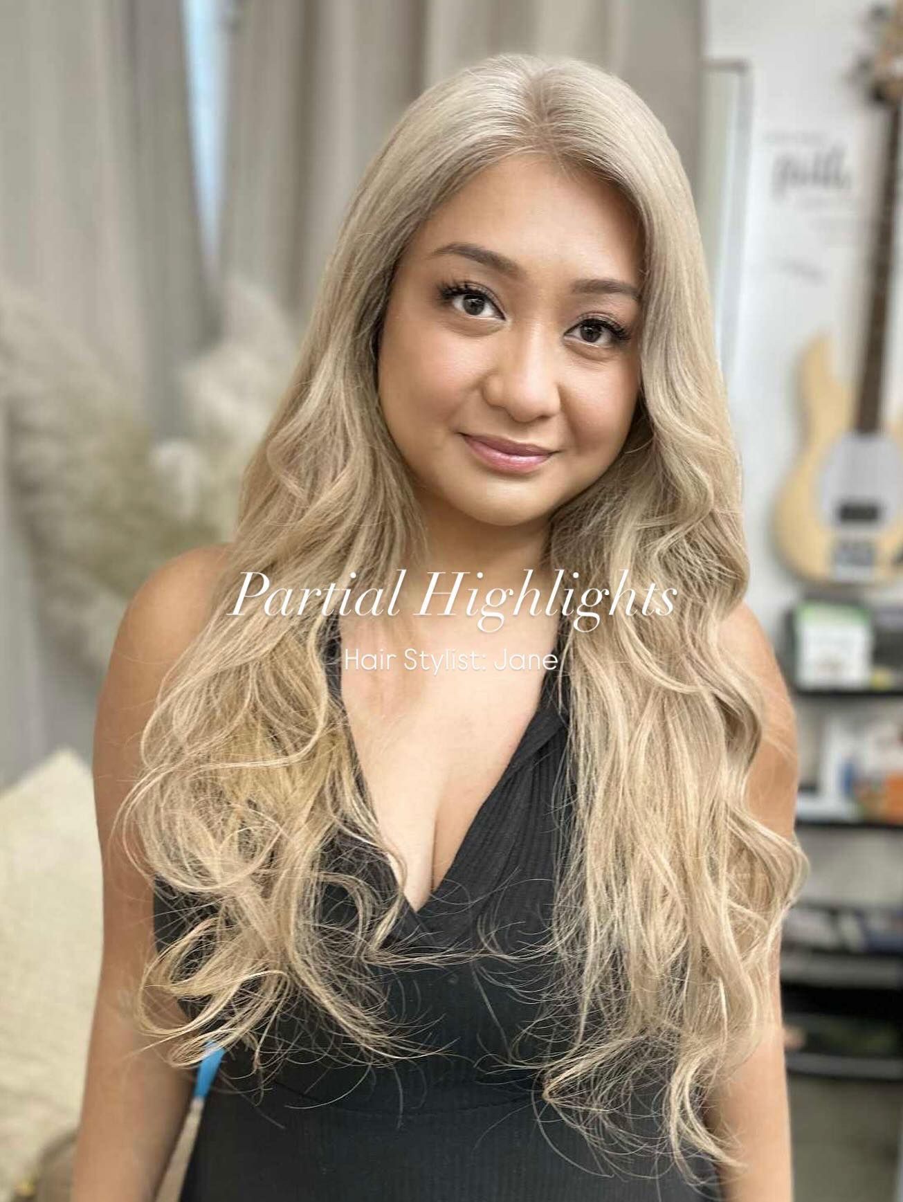 Woman with wavy, blonde hair. Wearing a black top. 