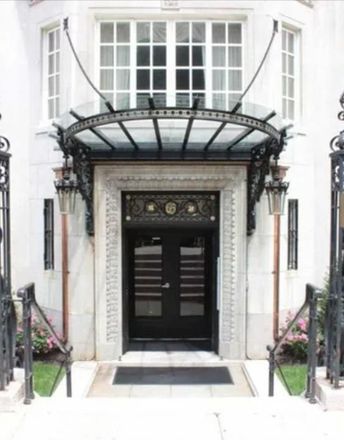 A white building with a black door and a glass canopy