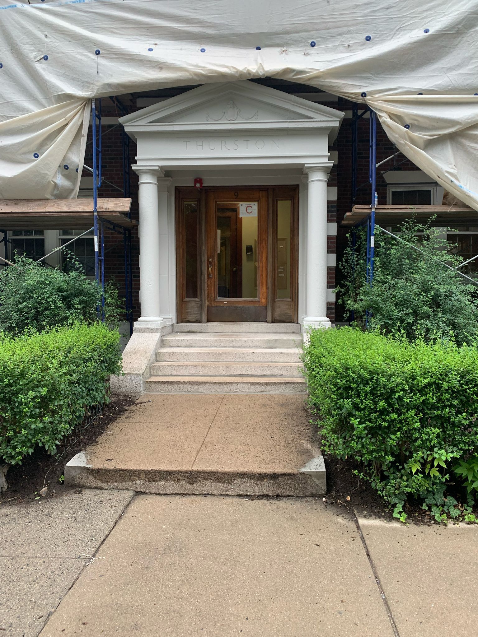 The front door of a building is covered in scaffolding