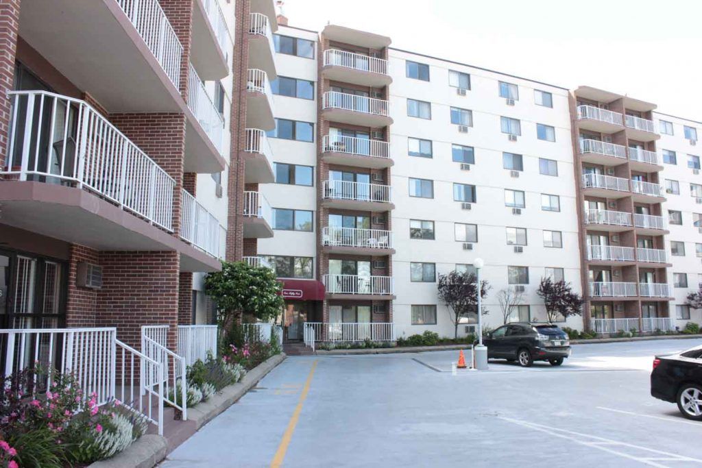 A large apartment building with cars parked in front of it