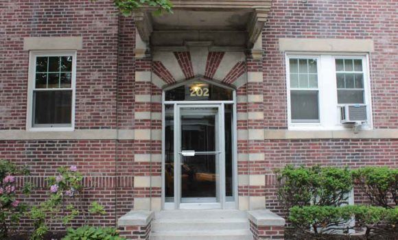 The front of a large building with a fence around it.