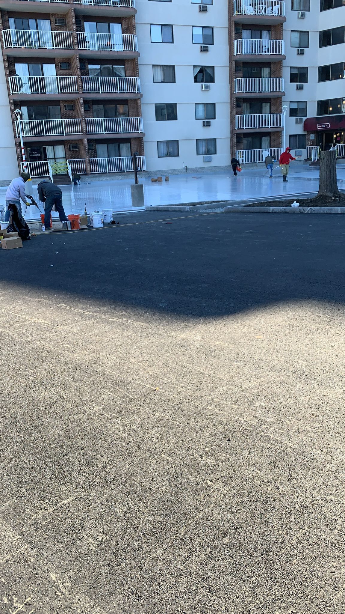 A group of people are working on a road in front of a building