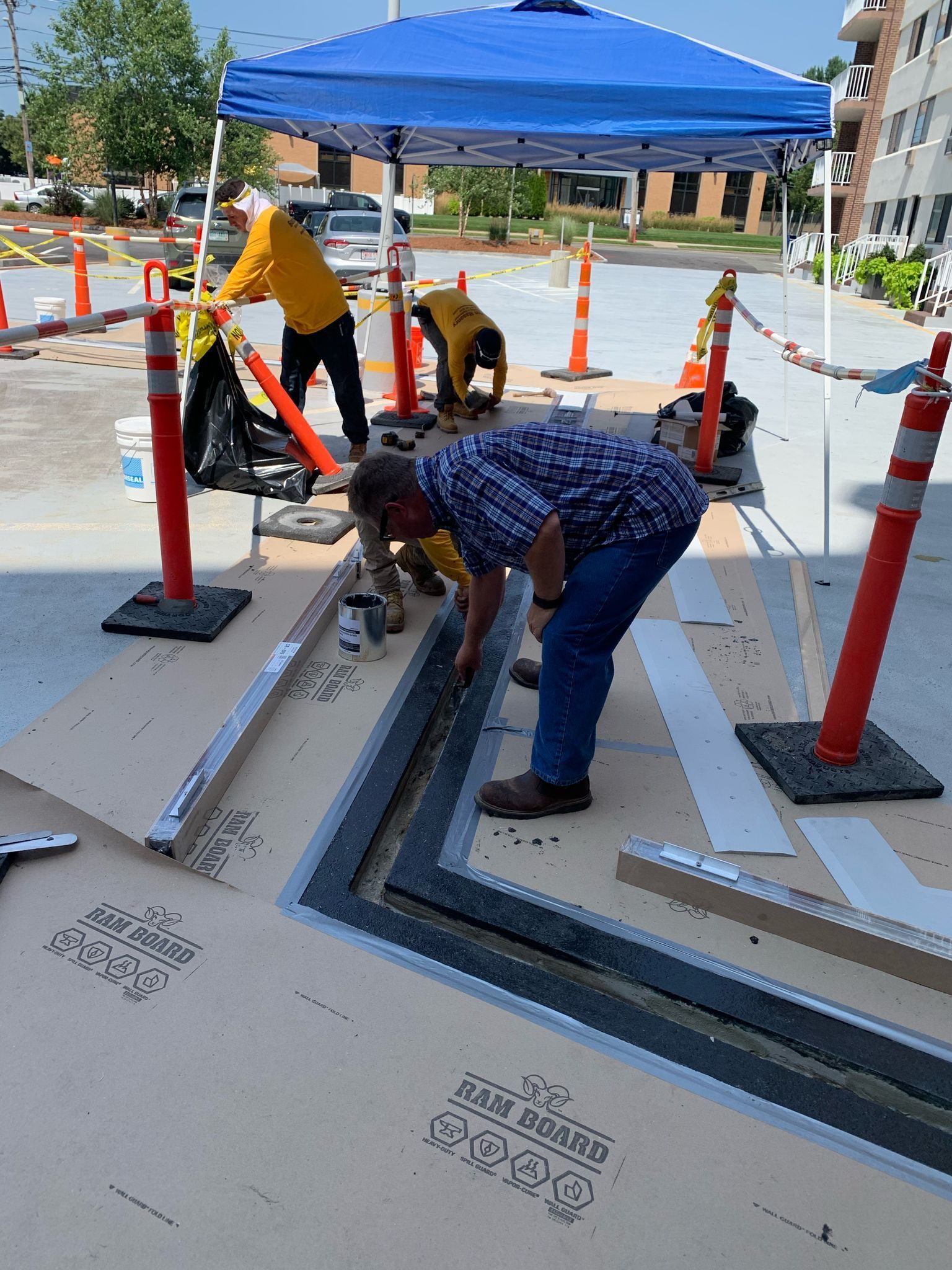 A group of men are working under a blue tent